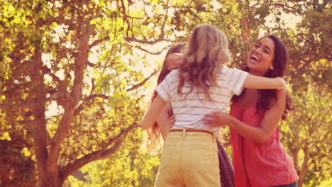 Happy-female-friends-talking-and-laughing-together-in-the-park