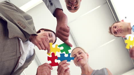 Business-colleagues-holding-pieces-of-puzzle