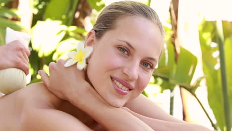 Woman-enjoying-a-herbal-compress-massage