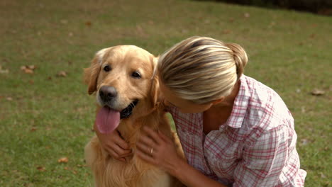 Glückliche-Blonde-Frau-Mit-Ihrem-Hund-Im-Park-