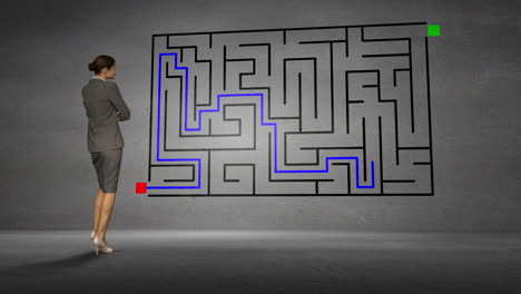 Businesswoman-looking-at-grey-wall-with-maze