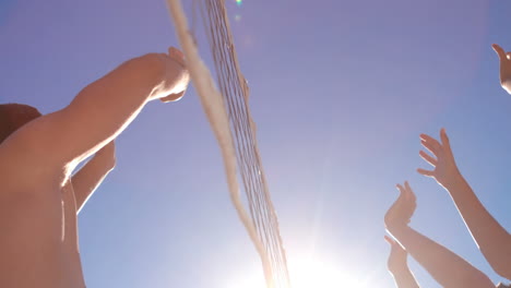 Attractive-young-friends-playing-beach-volleyball