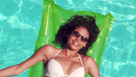 Attractive-woman-with-sunglasses-relaxing-on-lilo