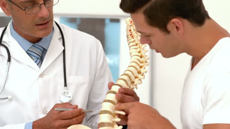 Doctor-showing-spine-model-to-patient