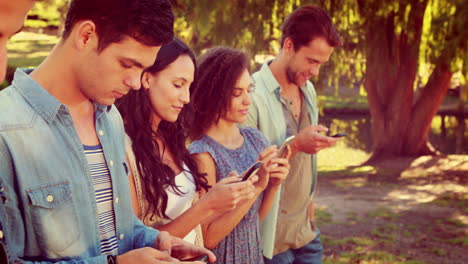 Happy-friends-in-the-park-using-their-phones