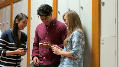 Students-on-their-smartphone-leaning-on-lockers