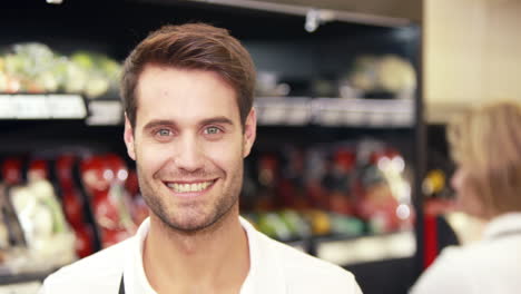 Joven-Miembro-Del-Personal-Sosteniendo-Una-Caja-De-Verduras-Y-Sonriendo-A-La-Cámara