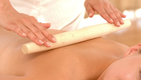 Beautiful-blonde-enjoying-a-bamboo-roller-massage