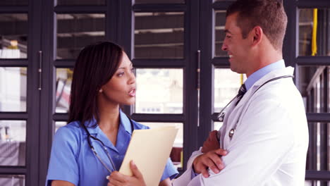 Smiling-doctor-talking-with-his-nurse