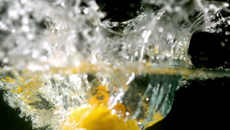 Lemons-falling-in-water-on-black-background