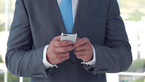 Close-up-of-businessman-using-his-smartphone