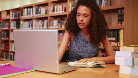 Serious-student-studying-and-smiling-at-camera-