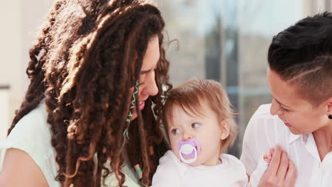 Lesbian-couple-with-their-child-on-the-couch