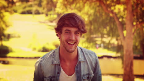 Handsome-man-smiling-at-camera-in-the-park