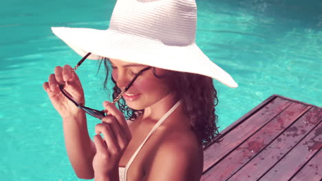 Attractive-woman-sitting-by-the-pool