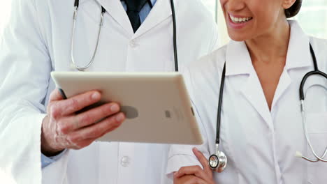 Happy-doctors-looking-at-tablet-computer-