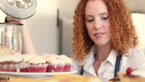 Pretty-woman-preparing-plate-of-cakes-