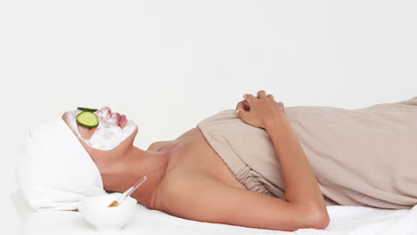 Woman-lying-on-massage-table-with-face-mask