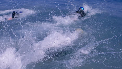 Tres-Surfistas-Atléticos-Sumergiéndose-En-El-Mar