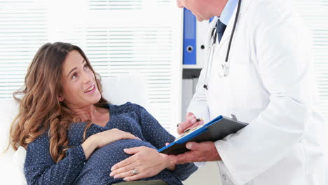 Doctor-talking-to-a-smiling-pregnant-woman