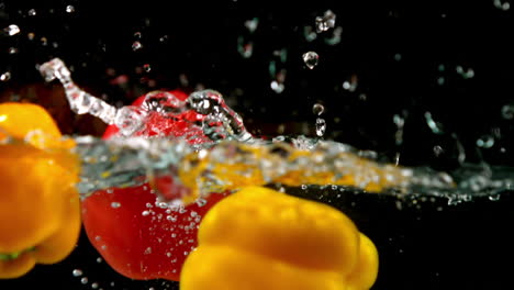 Paprika-Fallen-Ins-Wasser-Auf-Schwarzem-Hintergrund