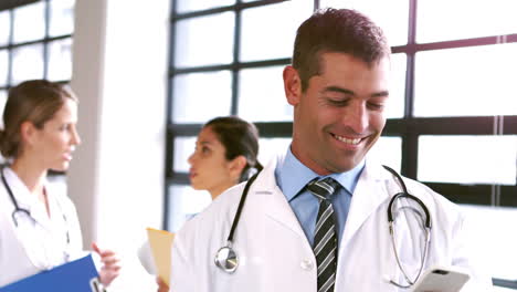 Médico-Masculino-Sonriente-Usando-Un-Teléfono-Inteligente