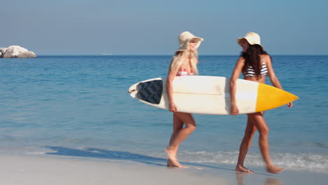 Two-surfers-woman-walking-with-surf-board-