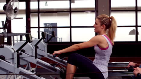 Fit-people-using-rowing-machine