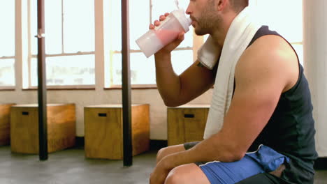 Fit-man-drinking-protein-shake-in-gym