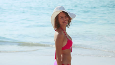 Pretty-brunette-smiling-at-camera-at-the-beach