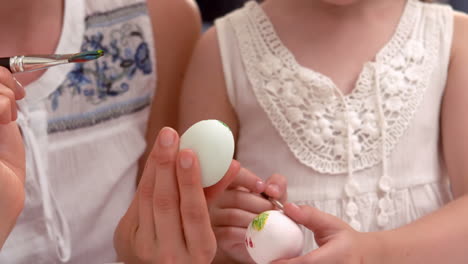 Happy-mother-and-daughter-painting-easter-eggs-