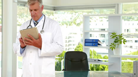 Happy-doctor-writing-on-clipboard-and-looking-at-camera