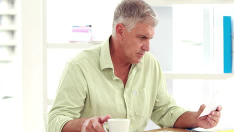 Casual-businessman-reading-notes-on-paper