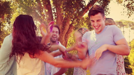 Happy-friends-throwing-powder-paint-in-the-park