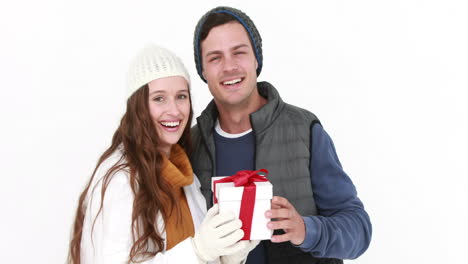 Casual-couple-in-warm-clothing-holding-gift