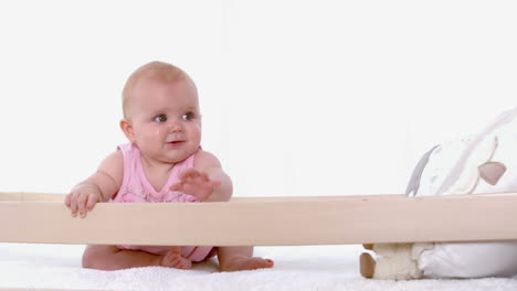 Baby-girl-waving-in-her-crib