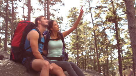 Couple-resting-after-hiking-and-pointing