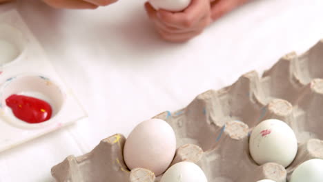 Happy-mother-and-daughter-painting-easter-eggs-