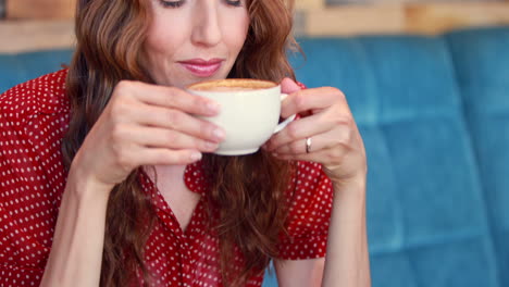 Pretty-woman-drinking-cappuccino-in-restaurant