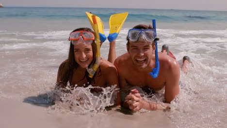 Happy-couple-lying-in-the-sand-with-mask-and-snorkel-