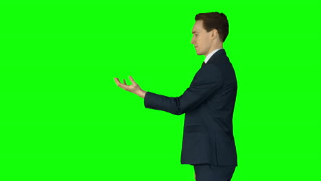 Businessman-lifting-something-on-his-hand-on-green-screen-