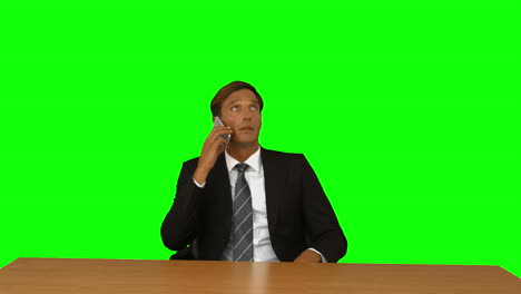 Businessman-sitting-at-desk-and-having-a-phone-call