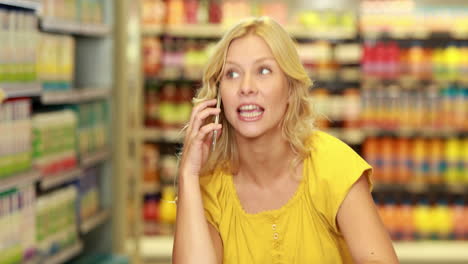 Pretty-blonde-making-a-phone-call-while-shopping