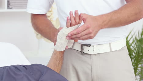 Doctor-bandaging-his-patients-hand