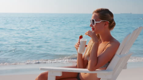 Pretty-blonde-drinking-cocktail-at-the-beach-