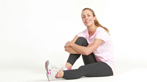 Smiling-fit-woman-tying-up-her-shoe-laces