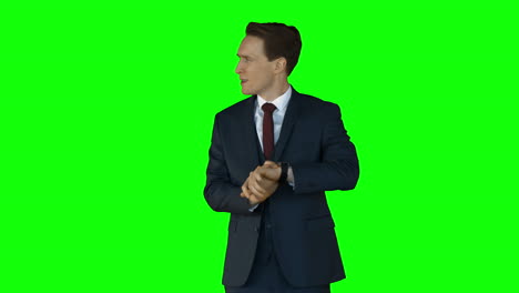 Irritated-businessman-checking-time-on-green-screen-