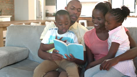 Padres-E-Hijos-Sentados-En-El-Sofá-Leyendo