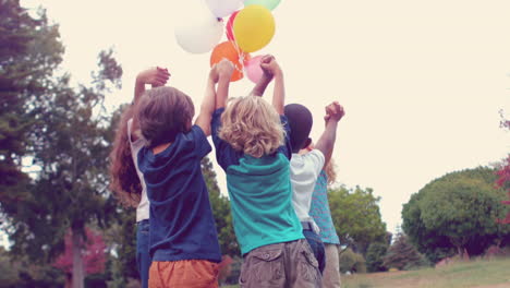 Niños-Felices-Sosteniendo-Globos