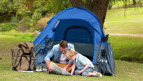 Father-and-son-looking-at-map-in-front-of-their-tent